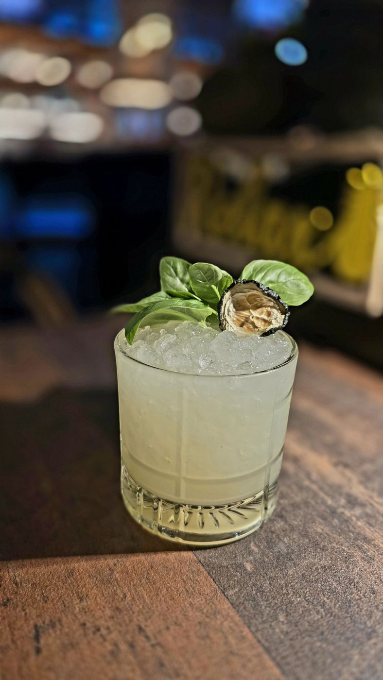 Cocktail with basil and a dehydrated wheel